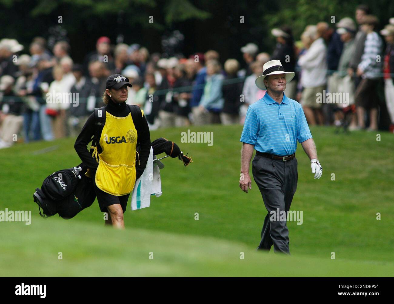 Tom Kite walks with his caddie, Sandra Jones, as they approach the first green in the third