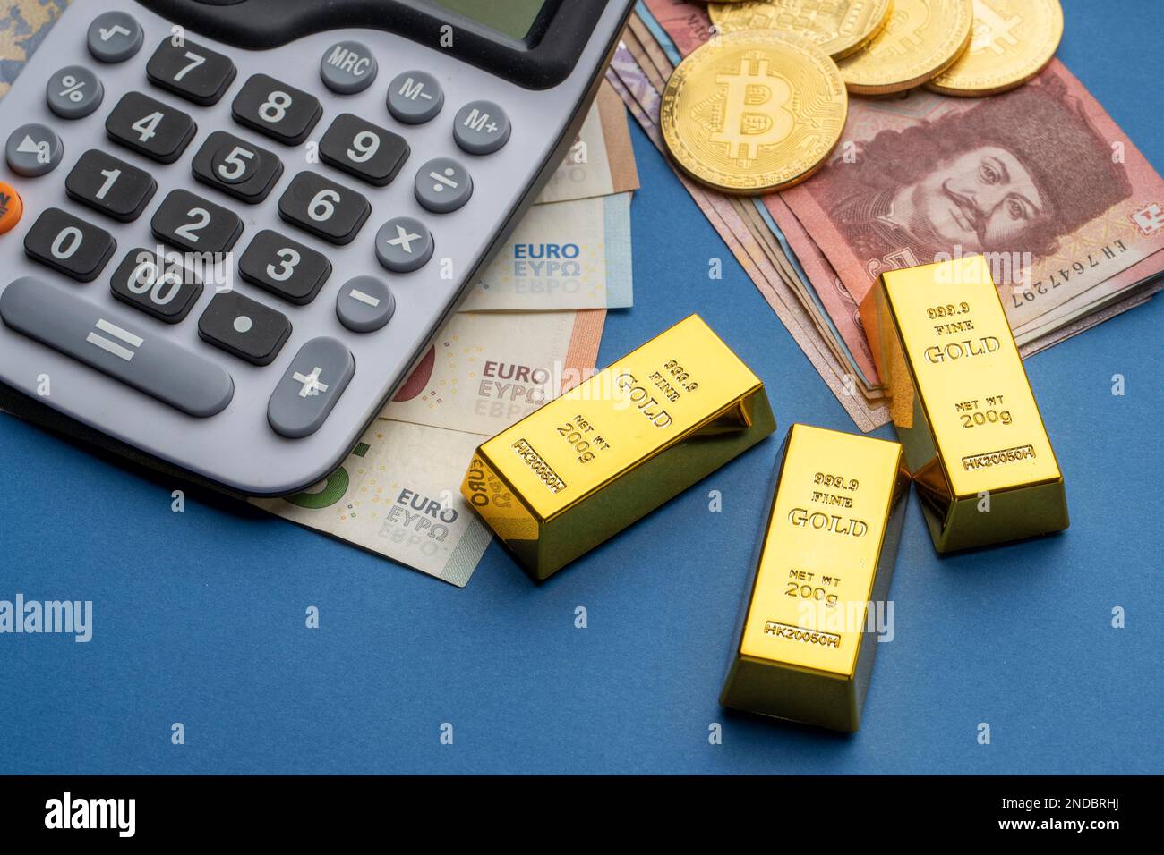 There are Hungarian forints and euro banknotes on a flat surface. A  calculator, gold blocks, and bitcoin coins are laid out next to it. HUF EUR  exchan Stock Photo - Alamy