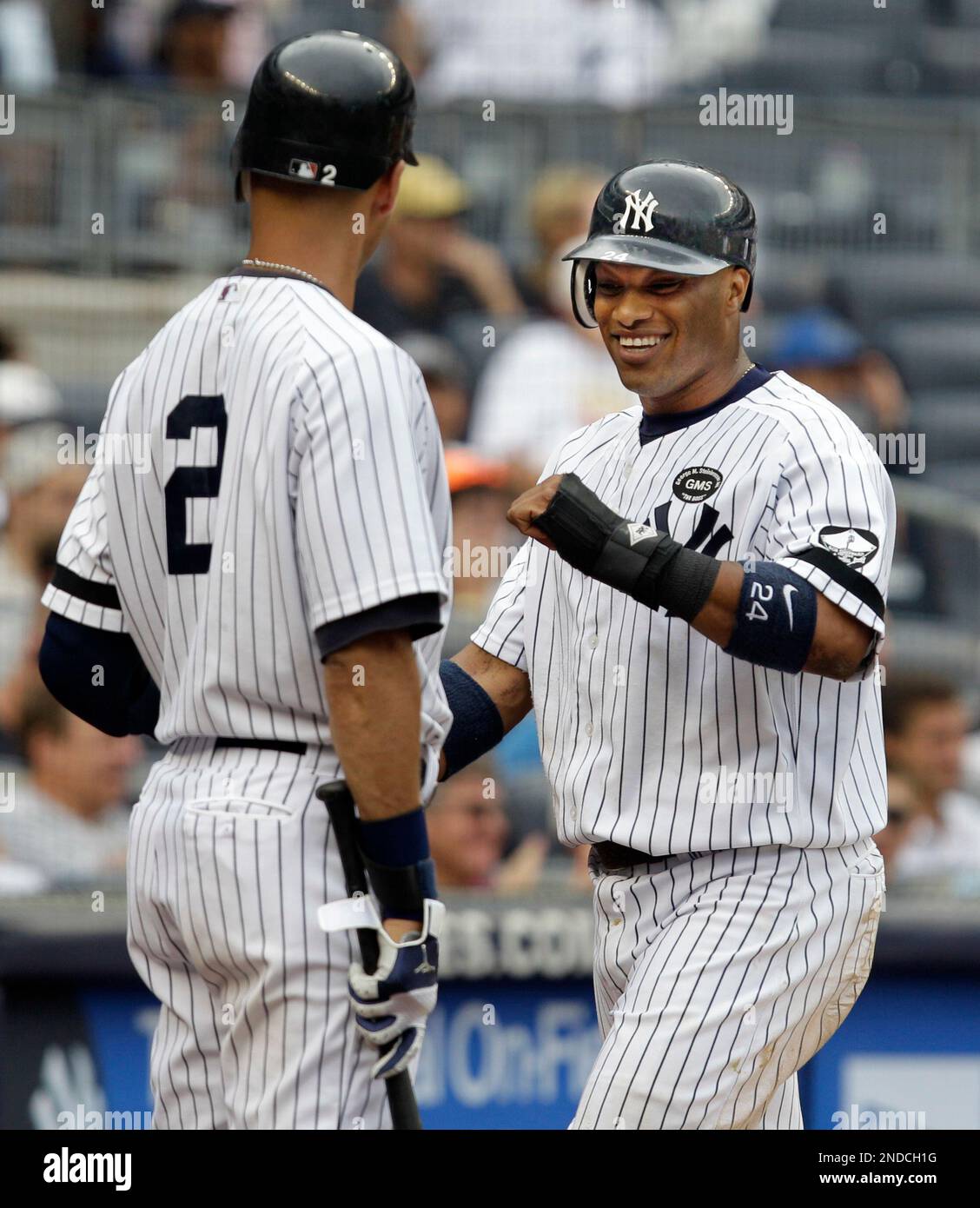 New York Yankees Derek Jeter (2) greets Robinson Cano at the plate after  Cano scored in the Yankees 12-6 victory over the Kansas City Royals in  their baseball game at Yankee Stadium