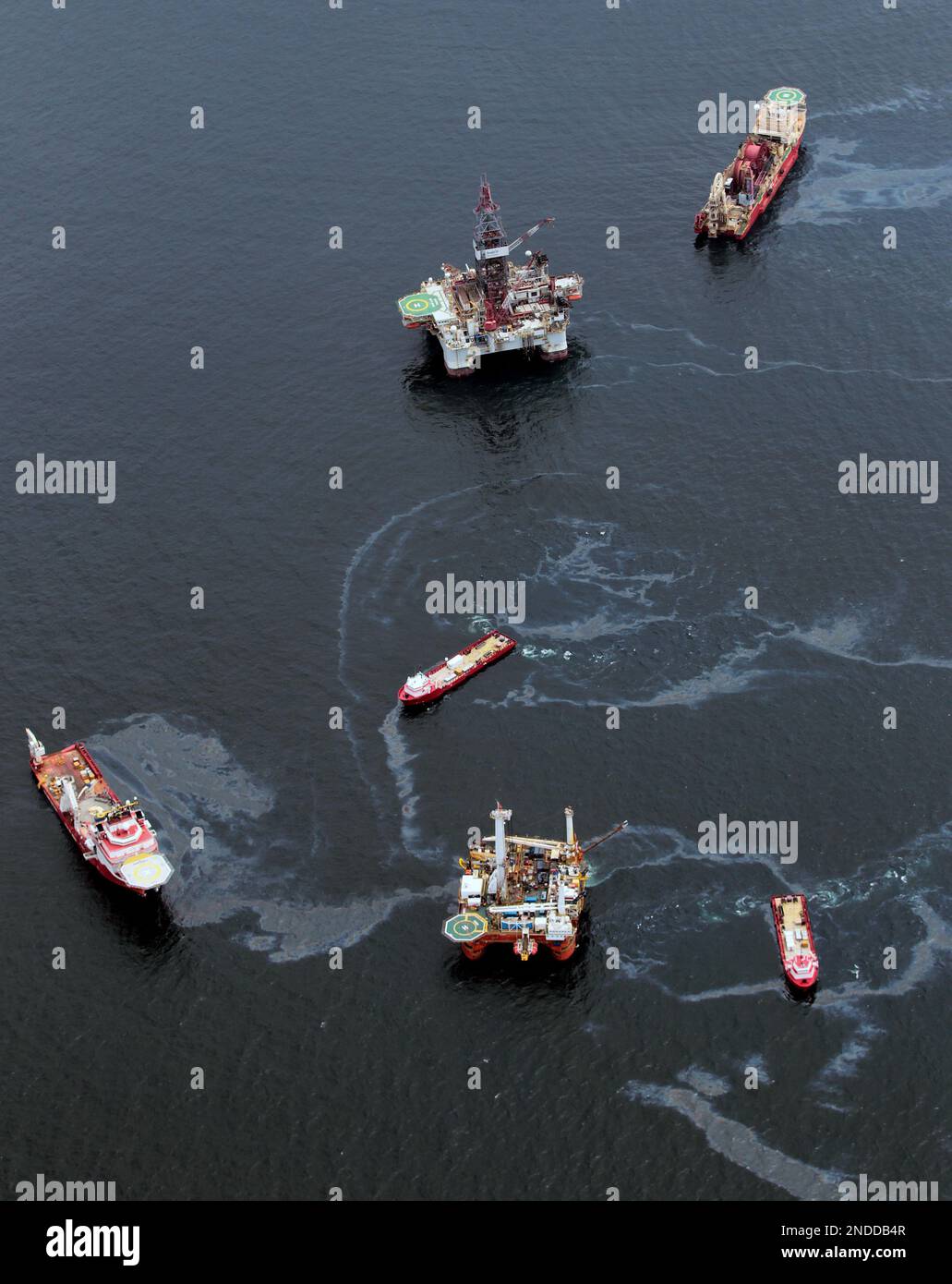 Drilling rigs and workboats operate at the site of the Deepwater ...