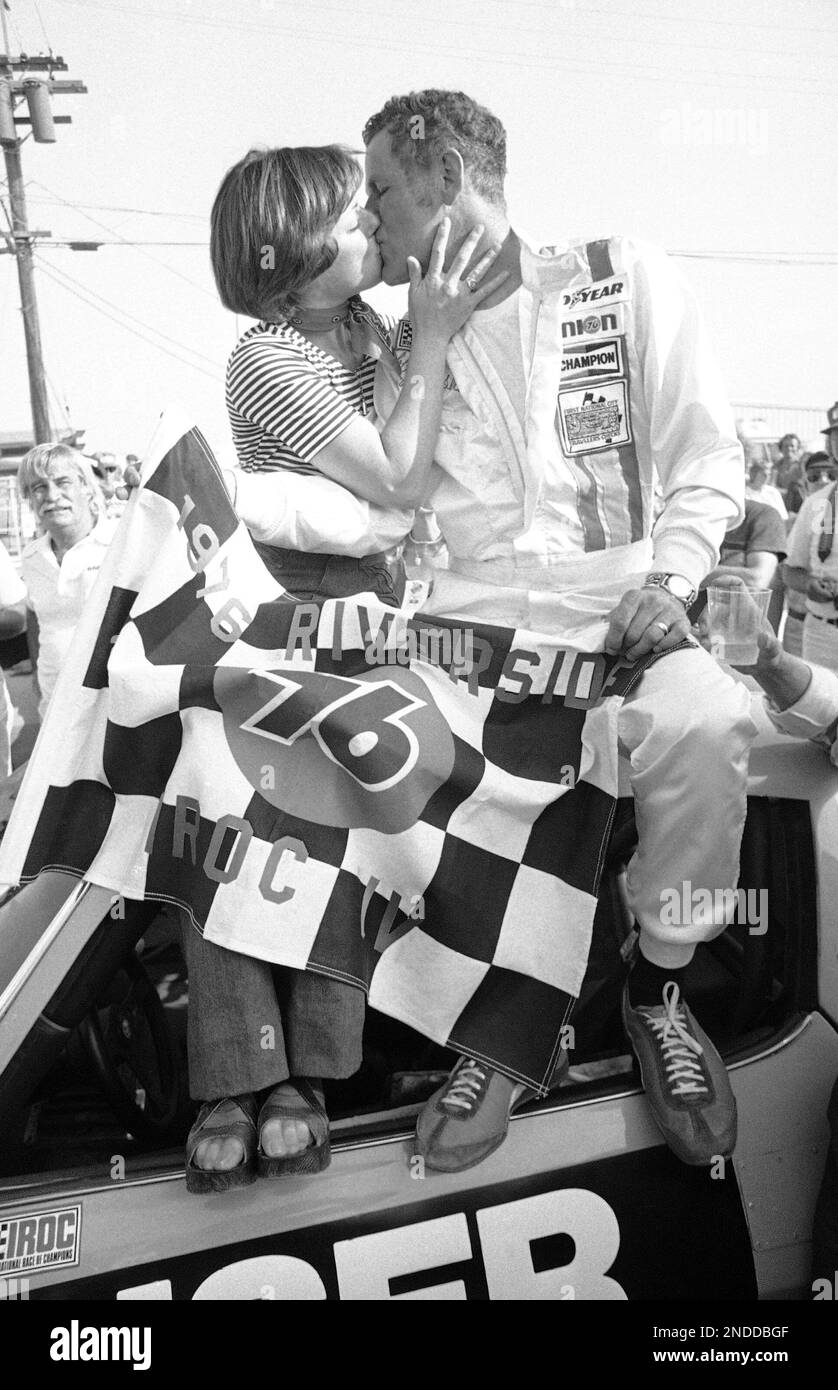 Bobby Unser receives a victory kiss from his wife, Marcia, after capturing the 76-mile International Race of Champions event at the Riverside, California Raceway, Oct. 16, 1976. Unser averaged 97.754 miles per hour to win the race, second in a four-race, $200,000 series. (AP Photo/George Brich) Stock Photo