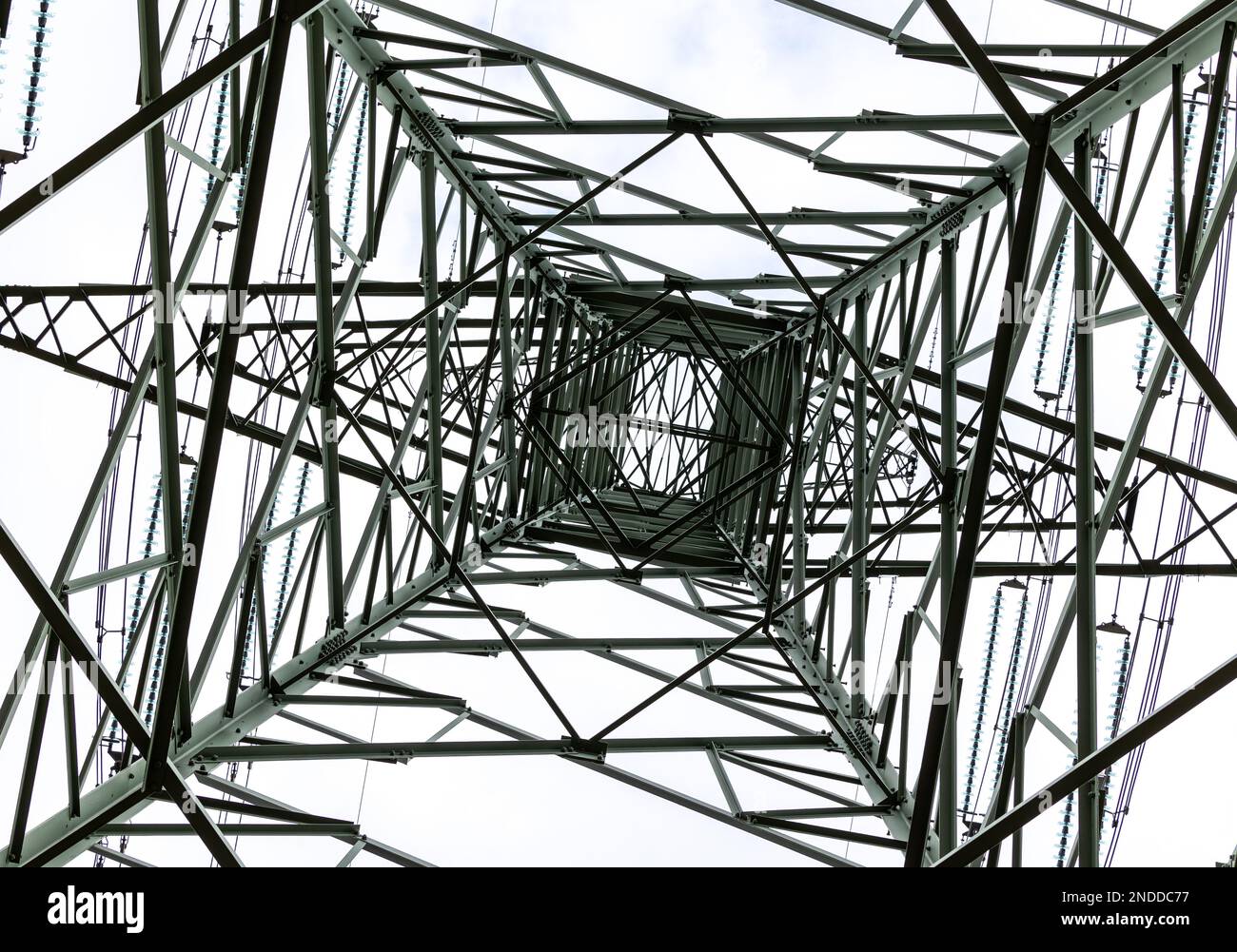High-voltage pylon seen from the position of the person standing underneath. High voltage transmission lines Stock Photo