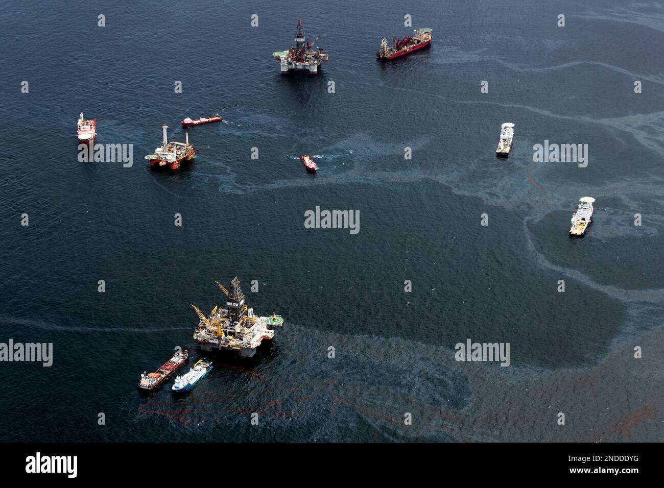 Drilling rigs and workboats operate at the site of the Deepwater ...