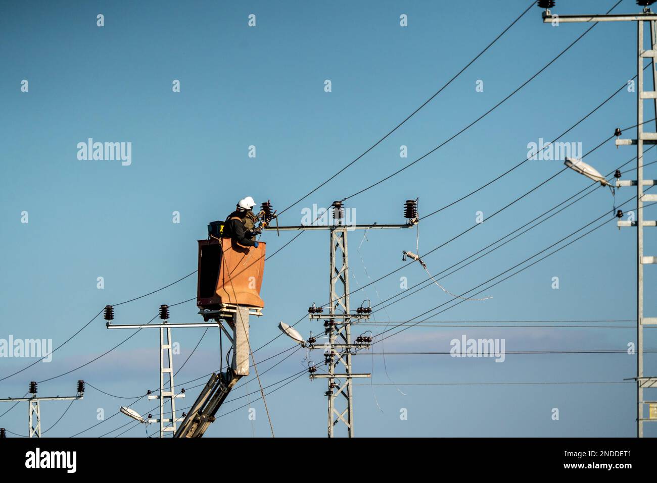Electrical workers are making a high voltage connection. Electricity poles and cables. Stock Photo