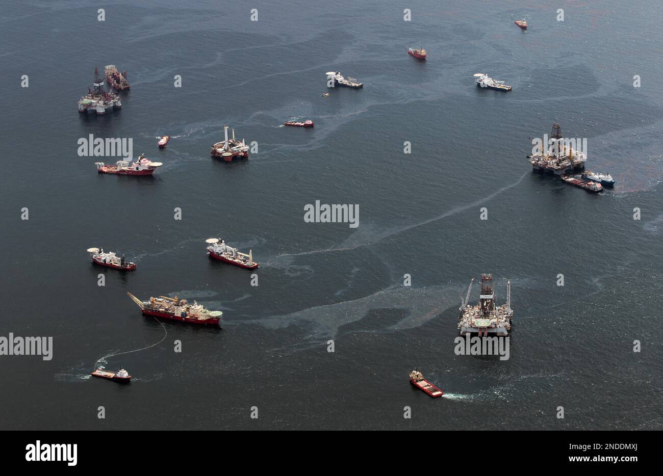 Drilling rigs and workboats operate at the site of the Deepwater ...