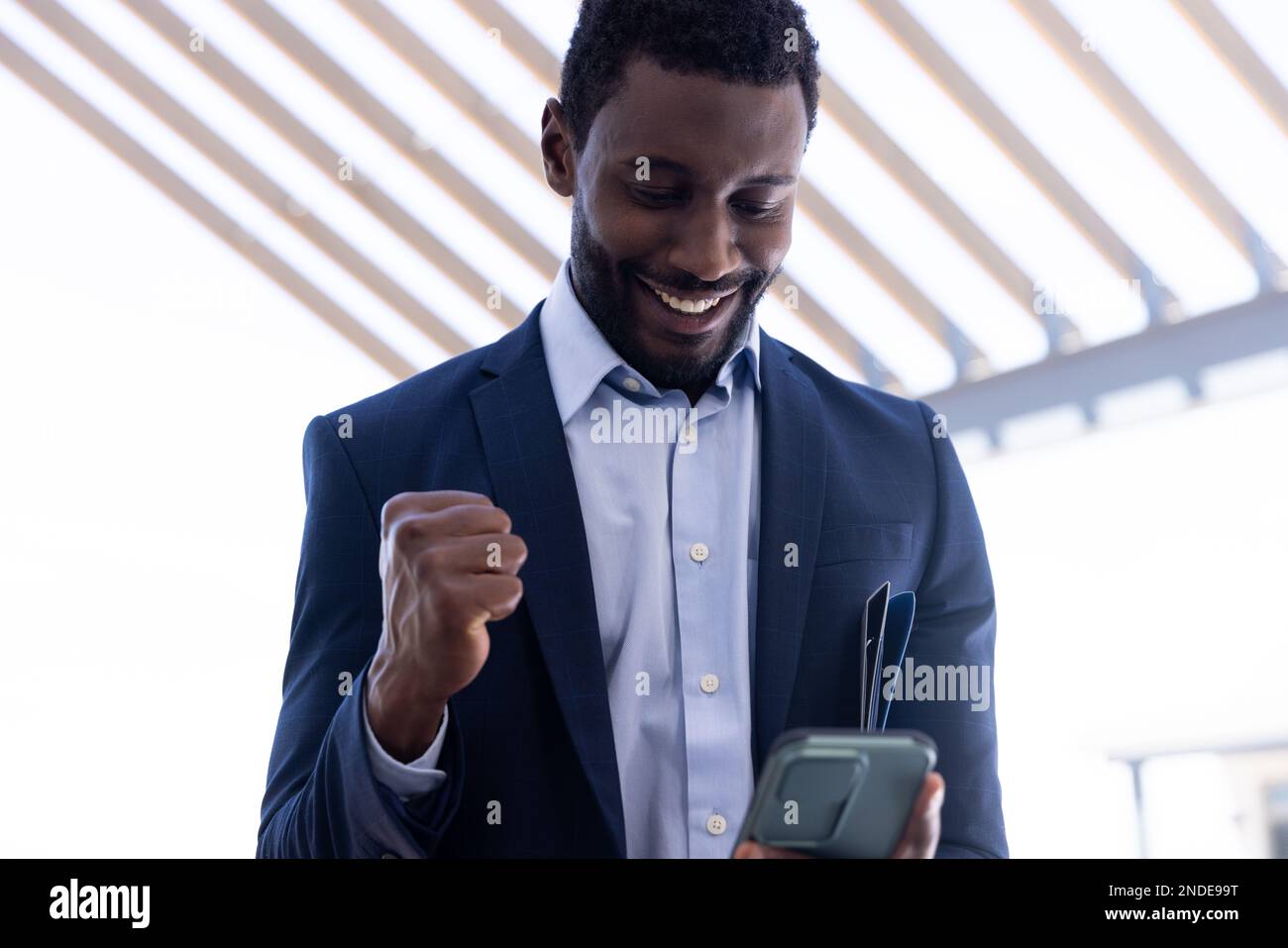 Happy african american businessman using tablet outside modern office ...
