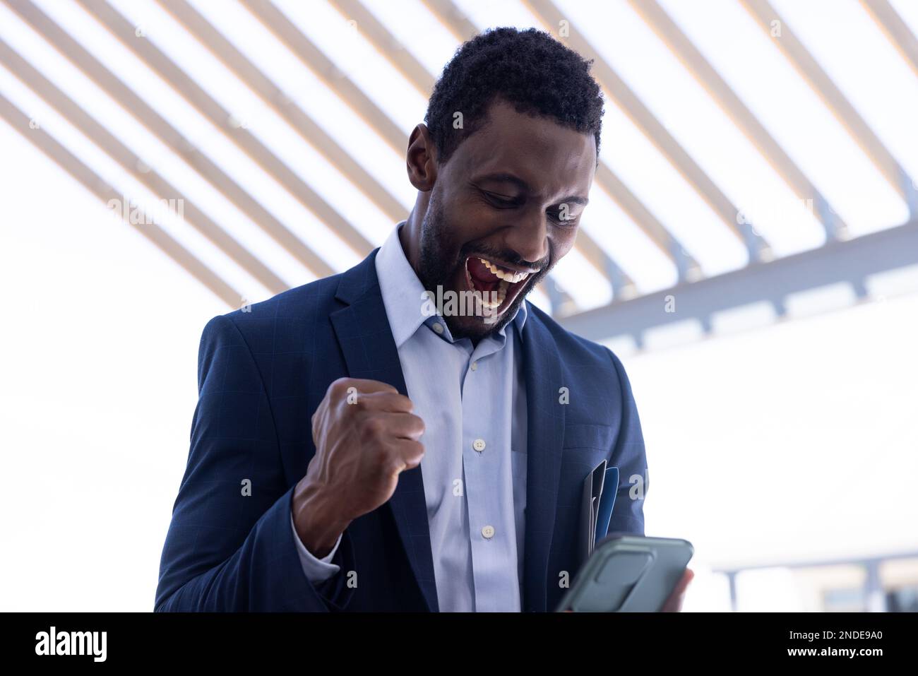 Happy african american businessman using tablet outside modern office ...