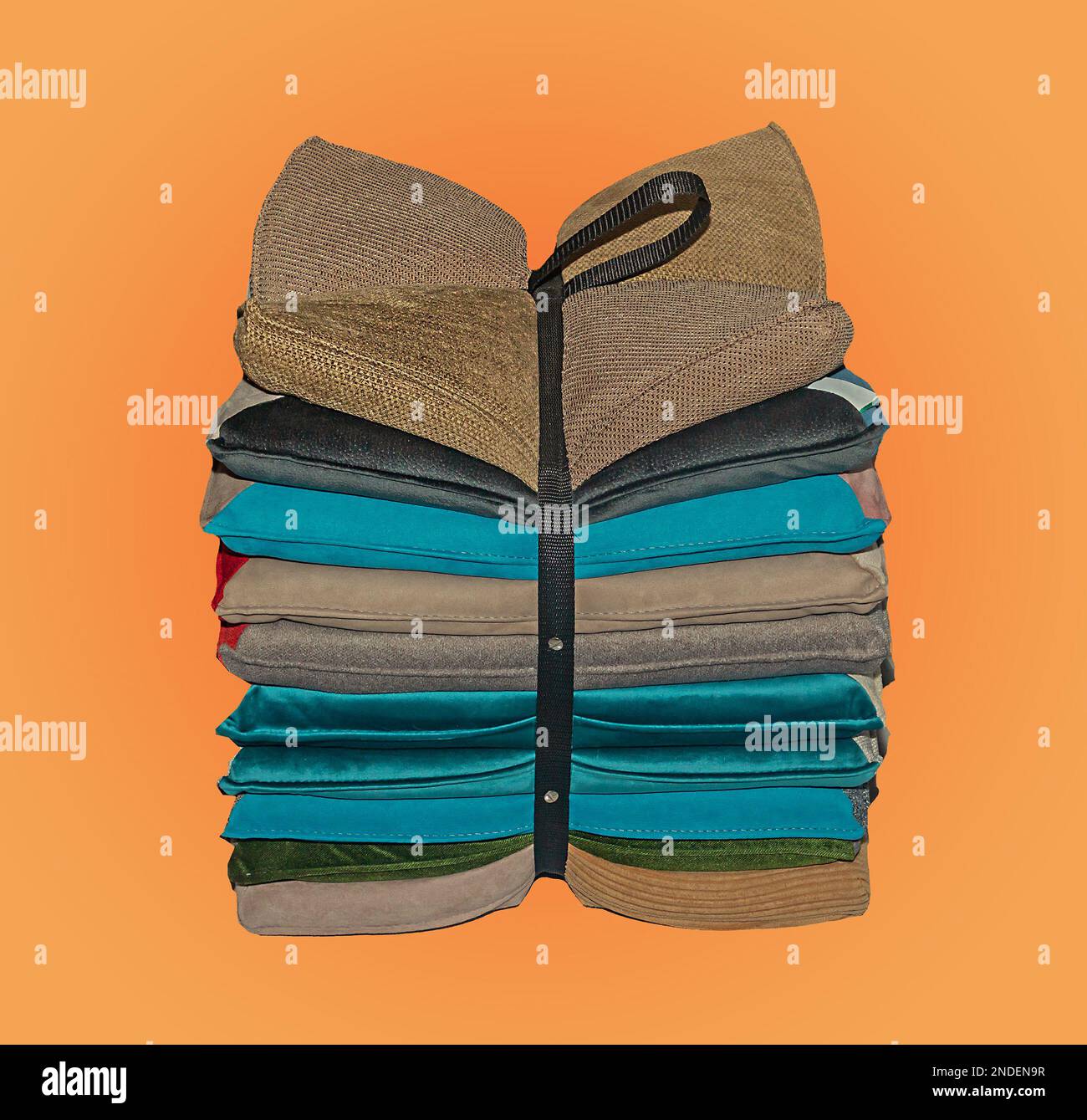Stack of colorful decorative pillows tied in a bow isolated on yellow background Stock Photo