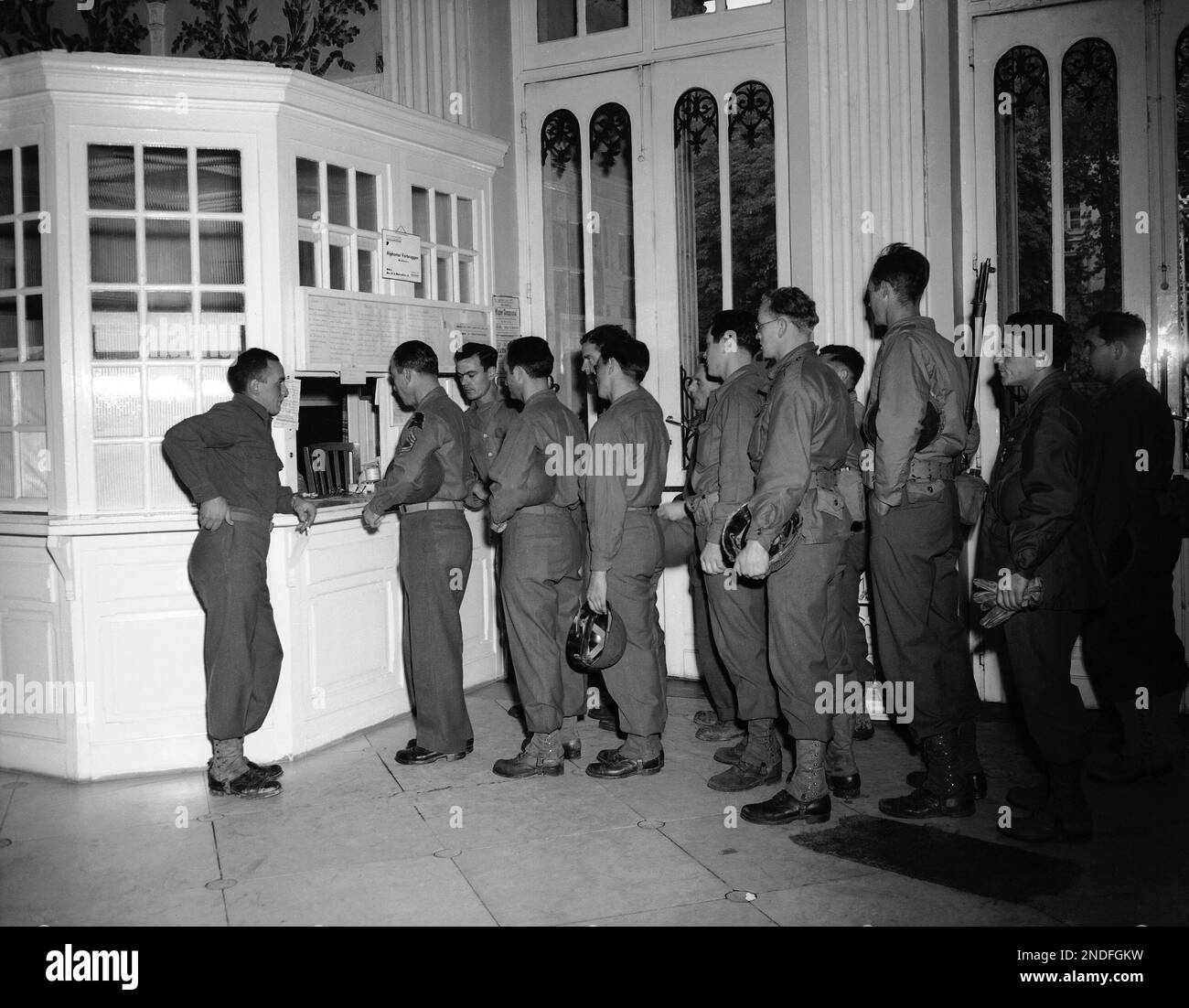 Inside the lobby of the bath house, GIs line up for their ticket which