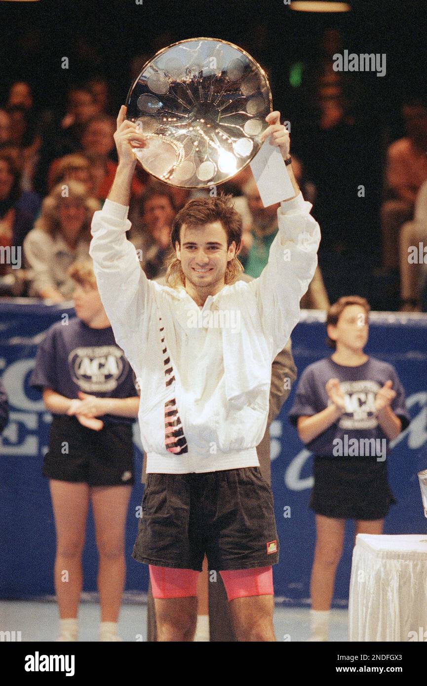 Andre Agassi holds his winning trophy after beating Todd Witsken in straight sets 6-1, 6-3 in the Volvo Tennis/San Francisco Tournament at the Civic Auditorium in San Francisco, Sunday, Feb. 11, 1990. Agassi also took home a winning purse of $32,400,000. (AP Photo/Martha Jane Stanton) Stock Photo