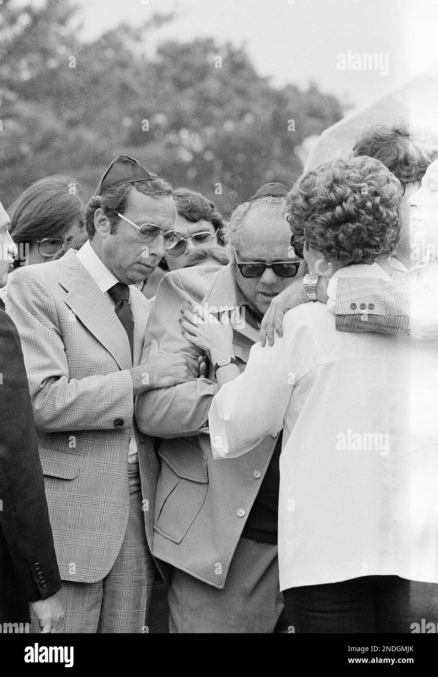 Jerome Moskowitz and his wife, Neysa, lean over the grave of their