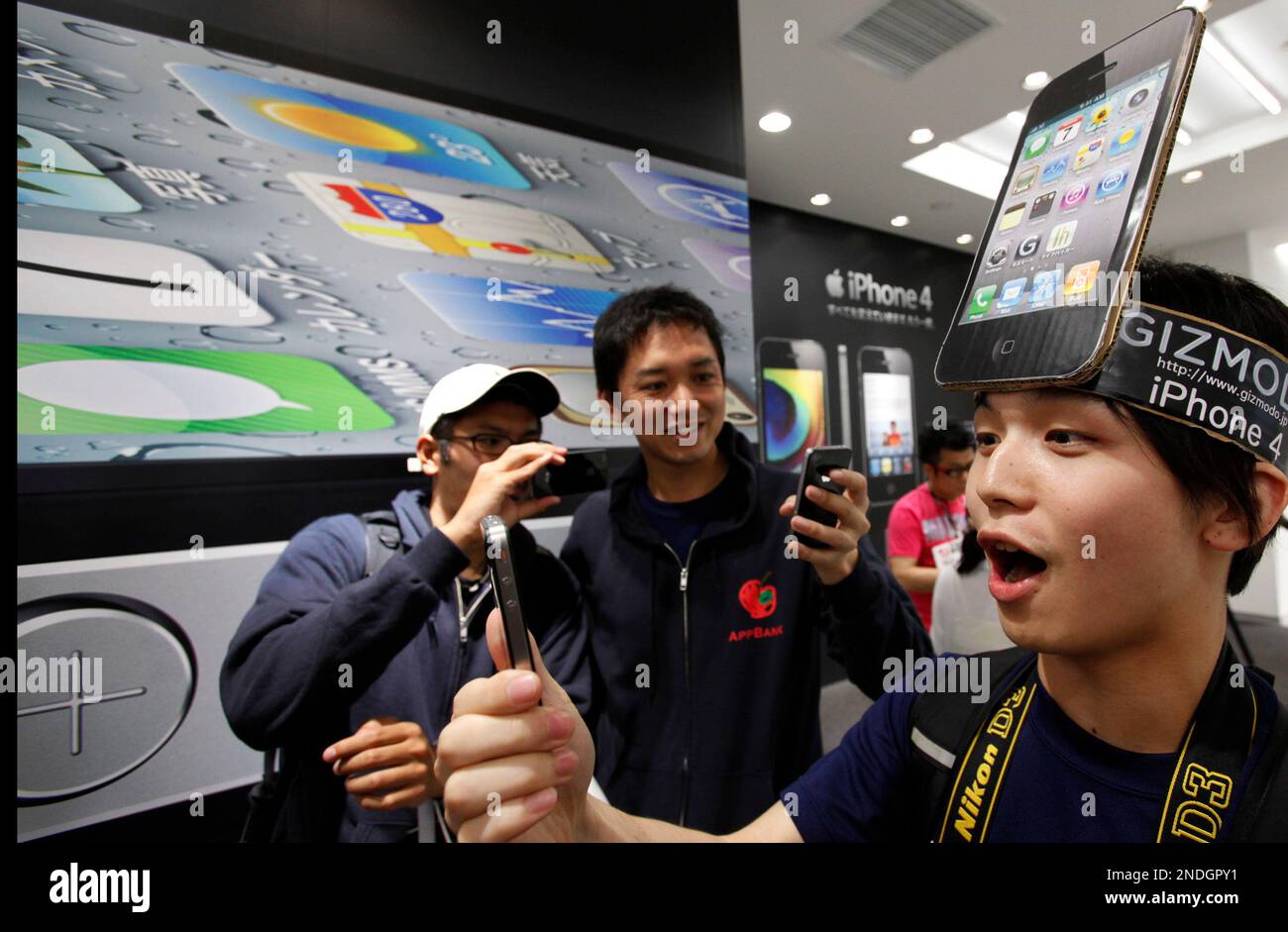 IPhone fan Mitsuru Endo, right, tries out Apple's latest iPhone4