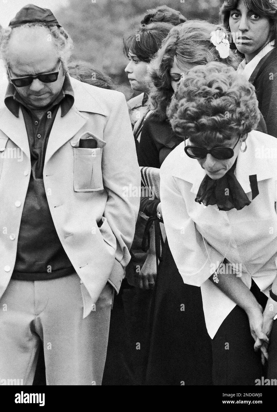 Jerome Moskowitz and his wife, Neysa, lean over the grave of their