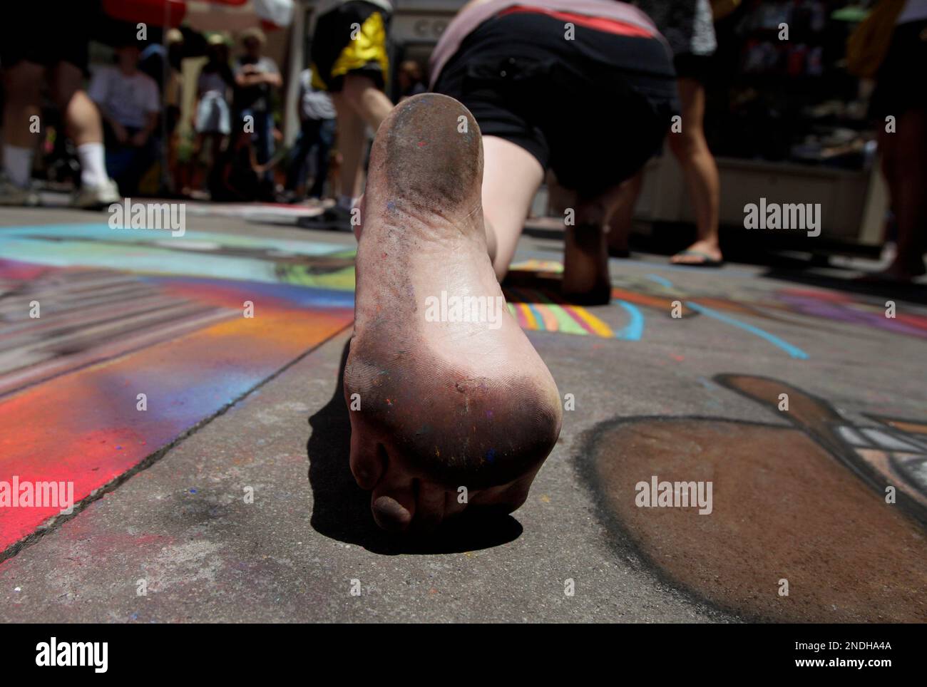 Chalk artist Kristin Mizar's foot is covered with chalk powder as she