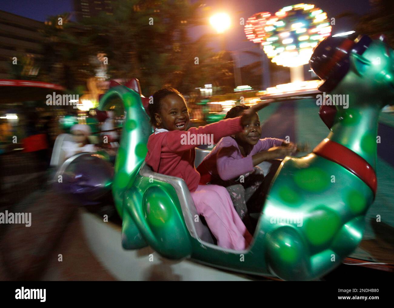 Two little sister enjoy an amusement park at the Durban beach, South