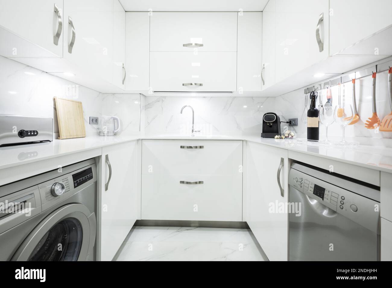 Ushaped fitted kitchen with glossy white gray appliances