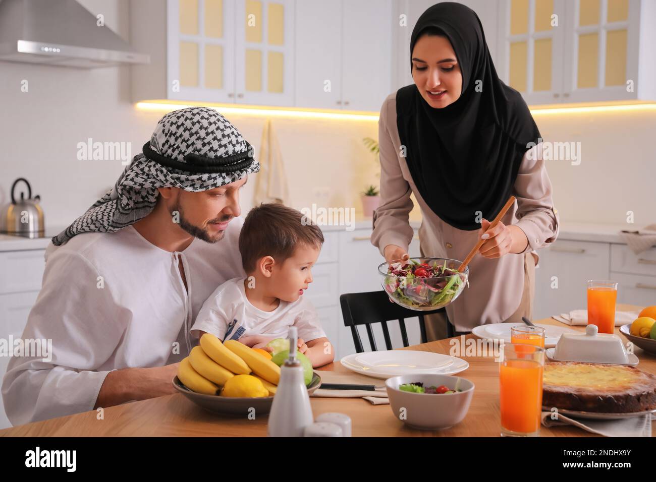 Happy Muslim family eating together in kitchen Stock Photo - Alamy