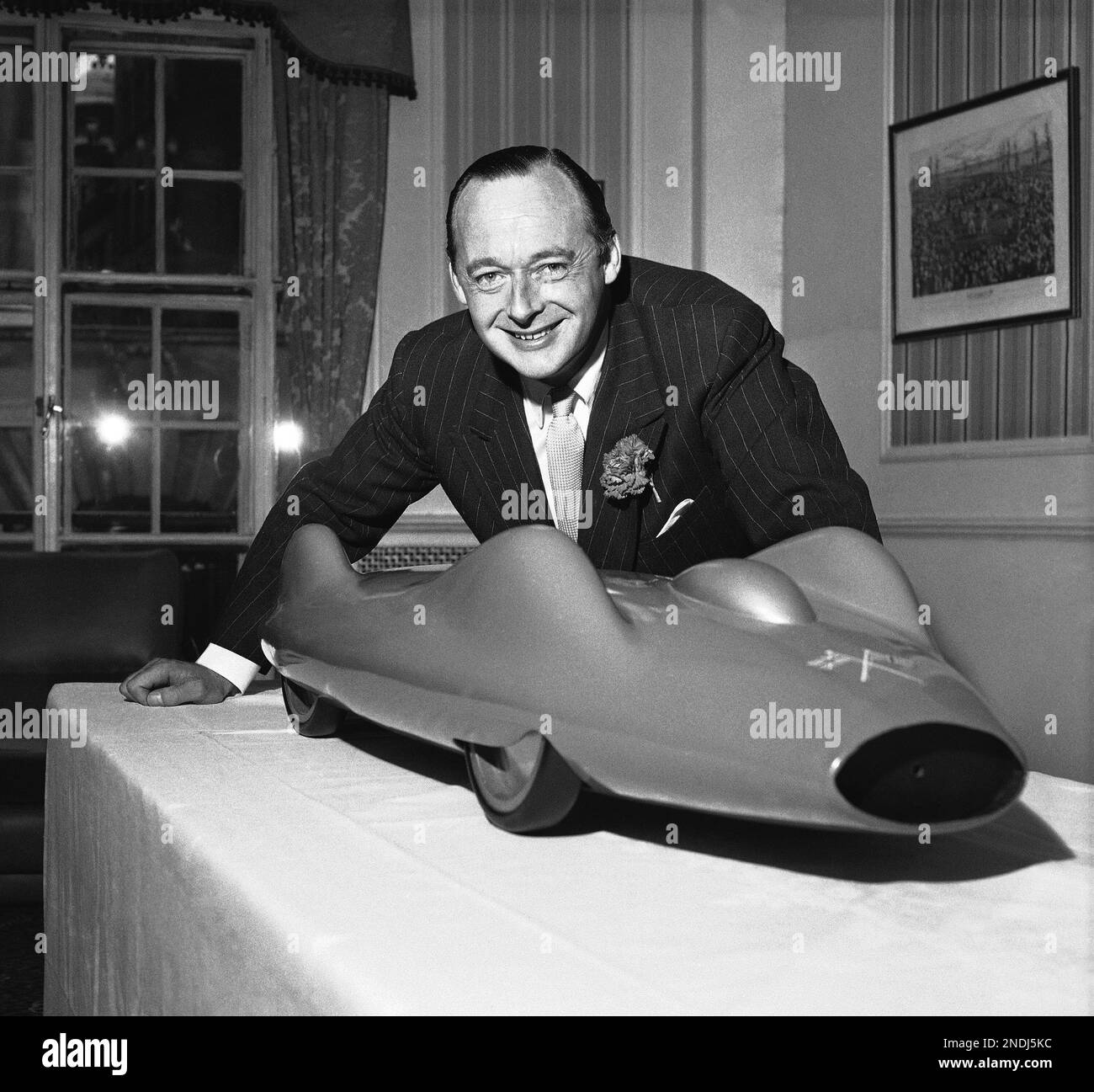 Donald Campbell of Britain, holder of the world water speed record, poses with a model of the