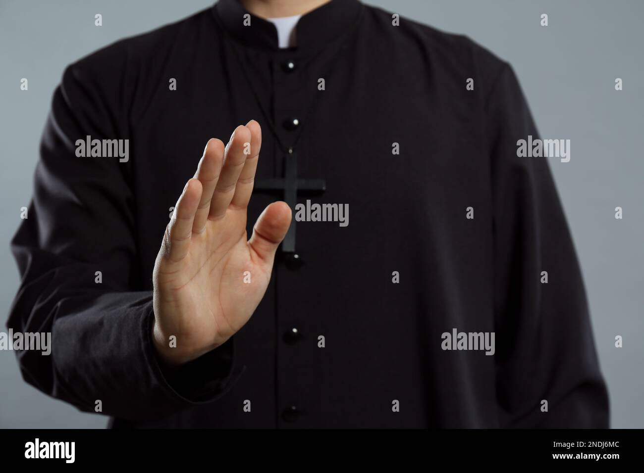 Priest making blessing gesture on grey background, closeup Stock Photo