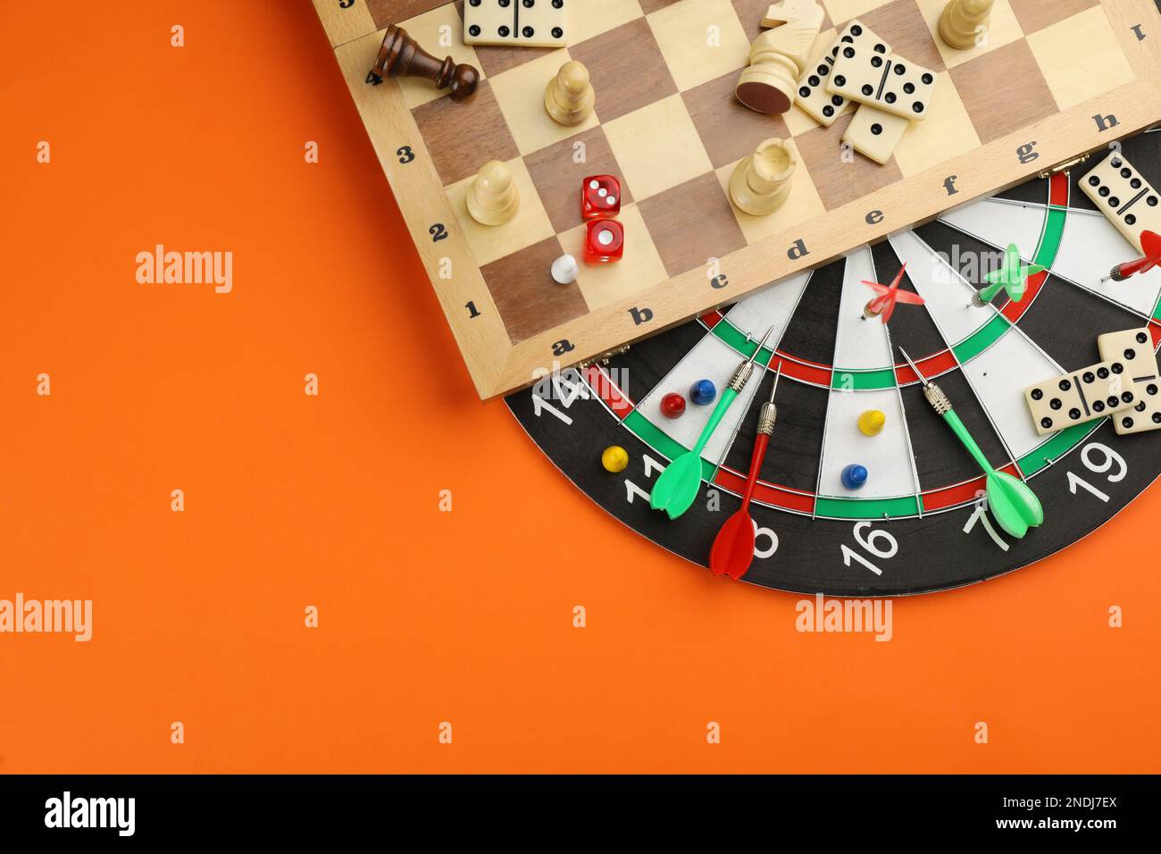Different types of board games and its' components on orange background
