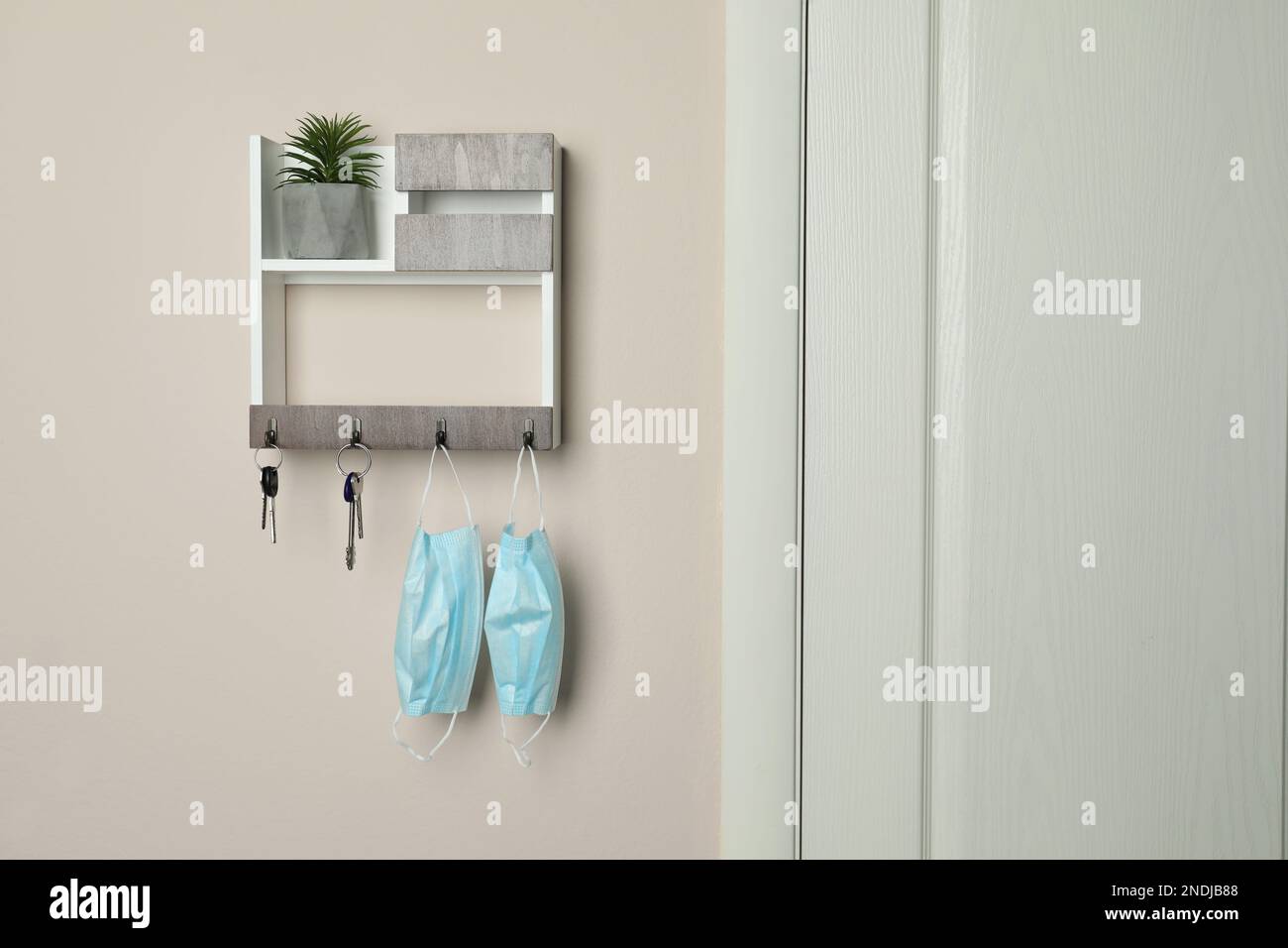 Wooden hanger for keys on beige wall Stock Photo Alamy