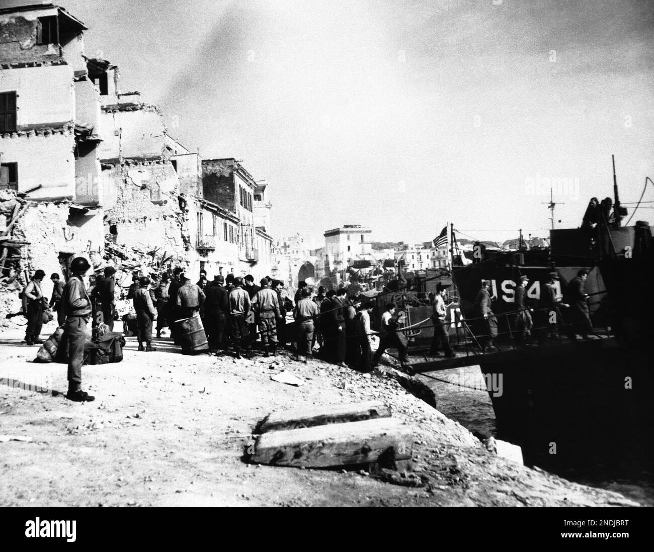 German Prisoners, captured during the fighting in the Anzio-Nettuno area of  Italy, are loaded on landing craft at Anzio Harbour in Italy on May 23,  1944. They are en route to a