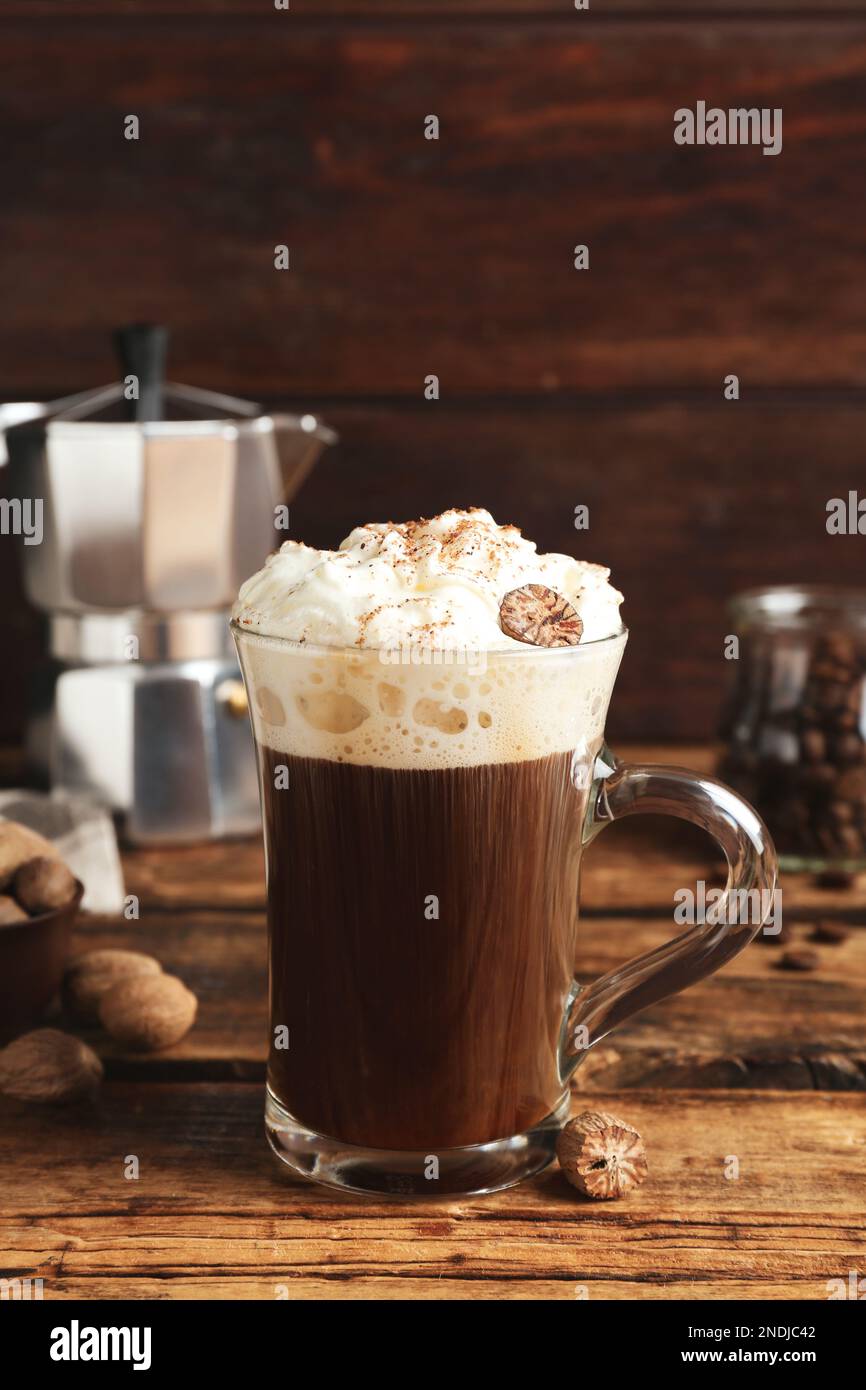 Coffee drink with nutmegs and whipped cream on wooden table Stock Photo