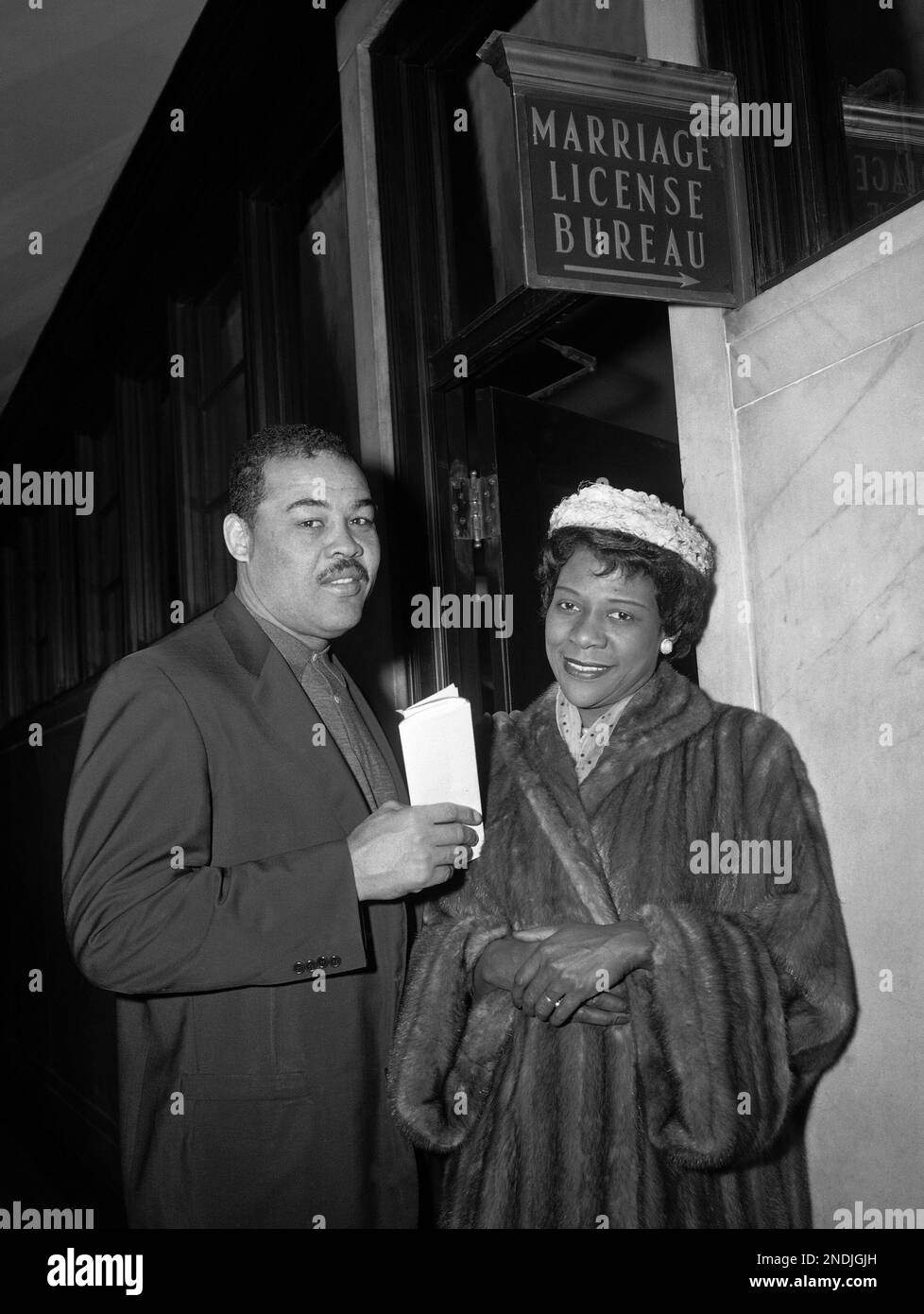 Former world heavyweight boxing champion Joe Louis, and Rose Morgan, a New  York city beauty shop owner, are shown at the door of the marriage license  bureau in the municipal building in