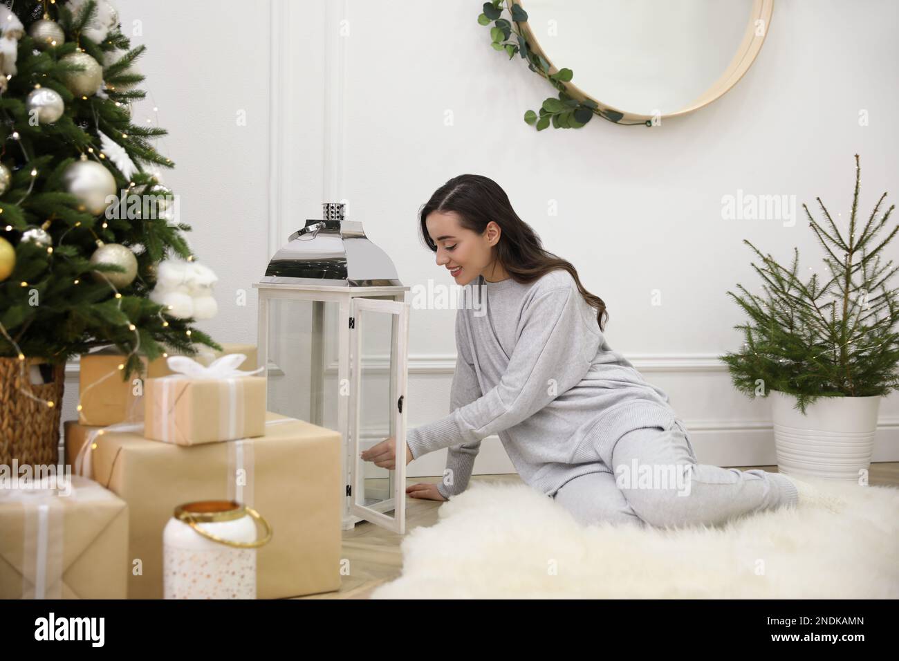 Woman lighting up candles on floor at home Stock Photo Alamy