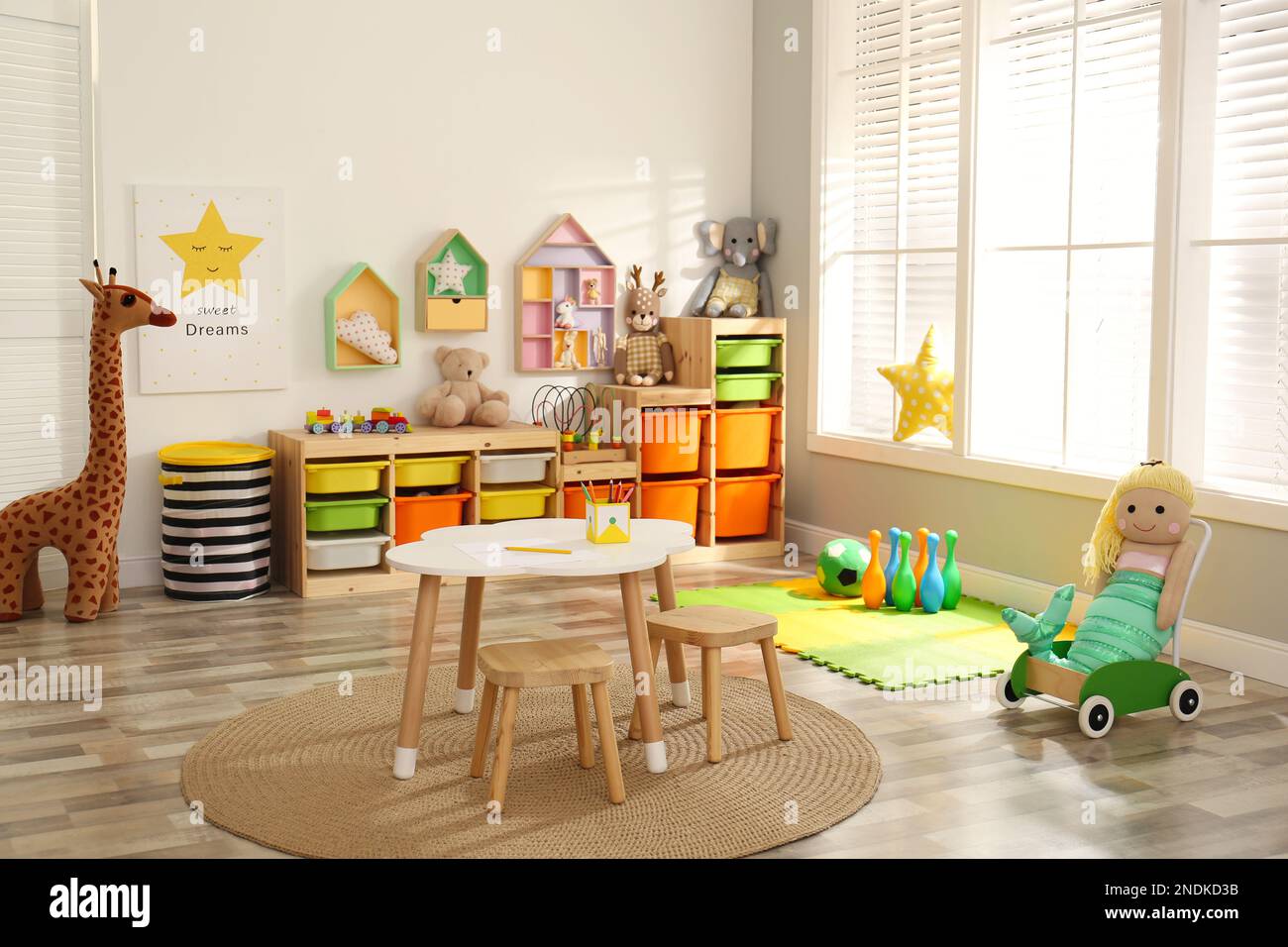 Stylish playroom interior with soft toys and modern furniture Stock Photo