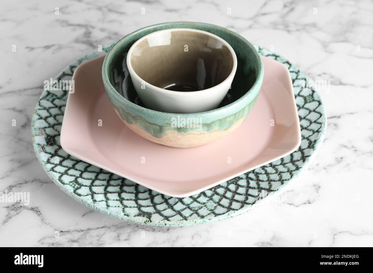 Stack of clean dishes on white marble table Stock Photo