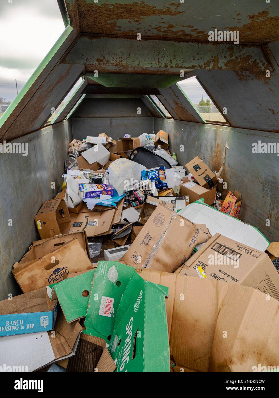 Trash and garbage and recycled paper and plastic in recycle bins in