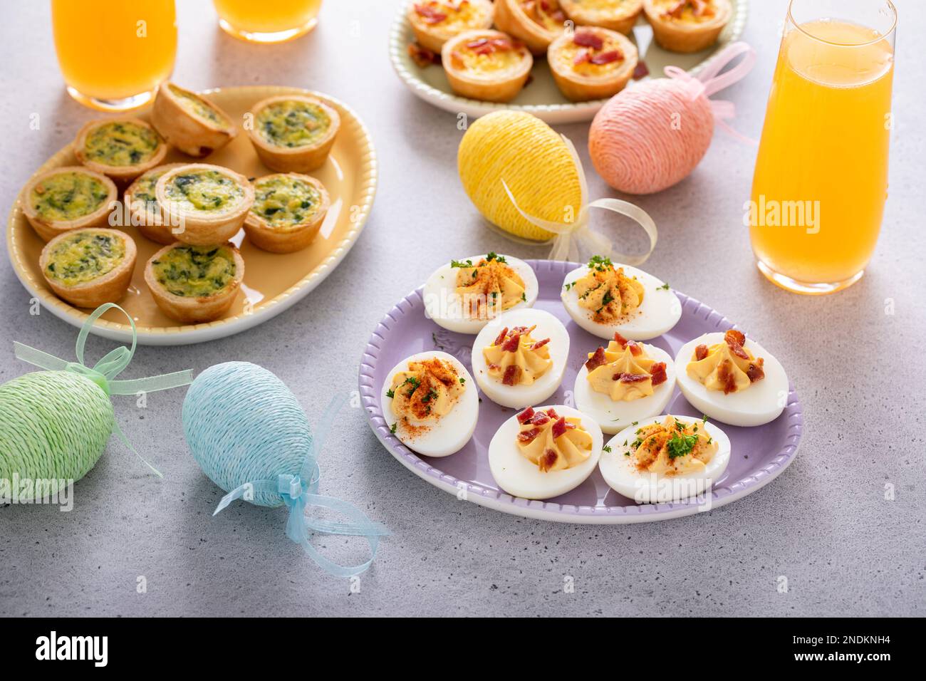 Deviled eggs and mini quiches appetizers for easter brunch with mimosa