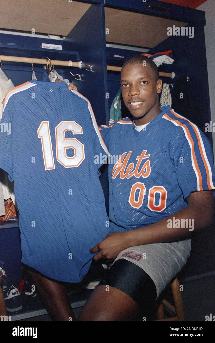 New York Mets starter Dwight “Doc” Gooden wears a jersey with the number  “00” while holding another with his current number “16” in the Mets  clubhouse in Port St. Lucie, Saturday, Feb.