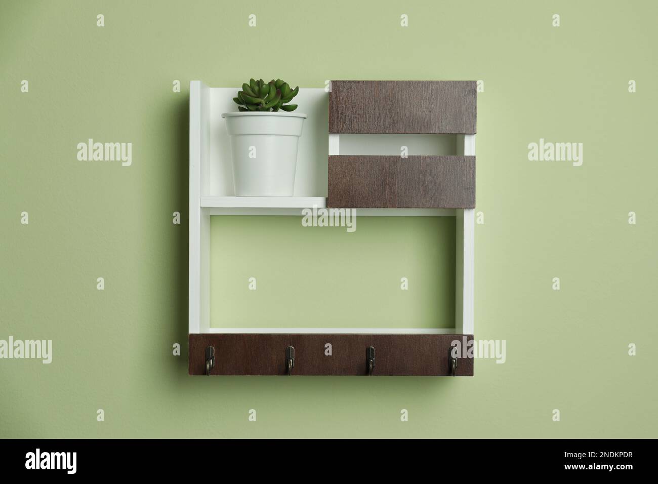 Wooden hanger for keys on light green wall Stock Photo Alamy