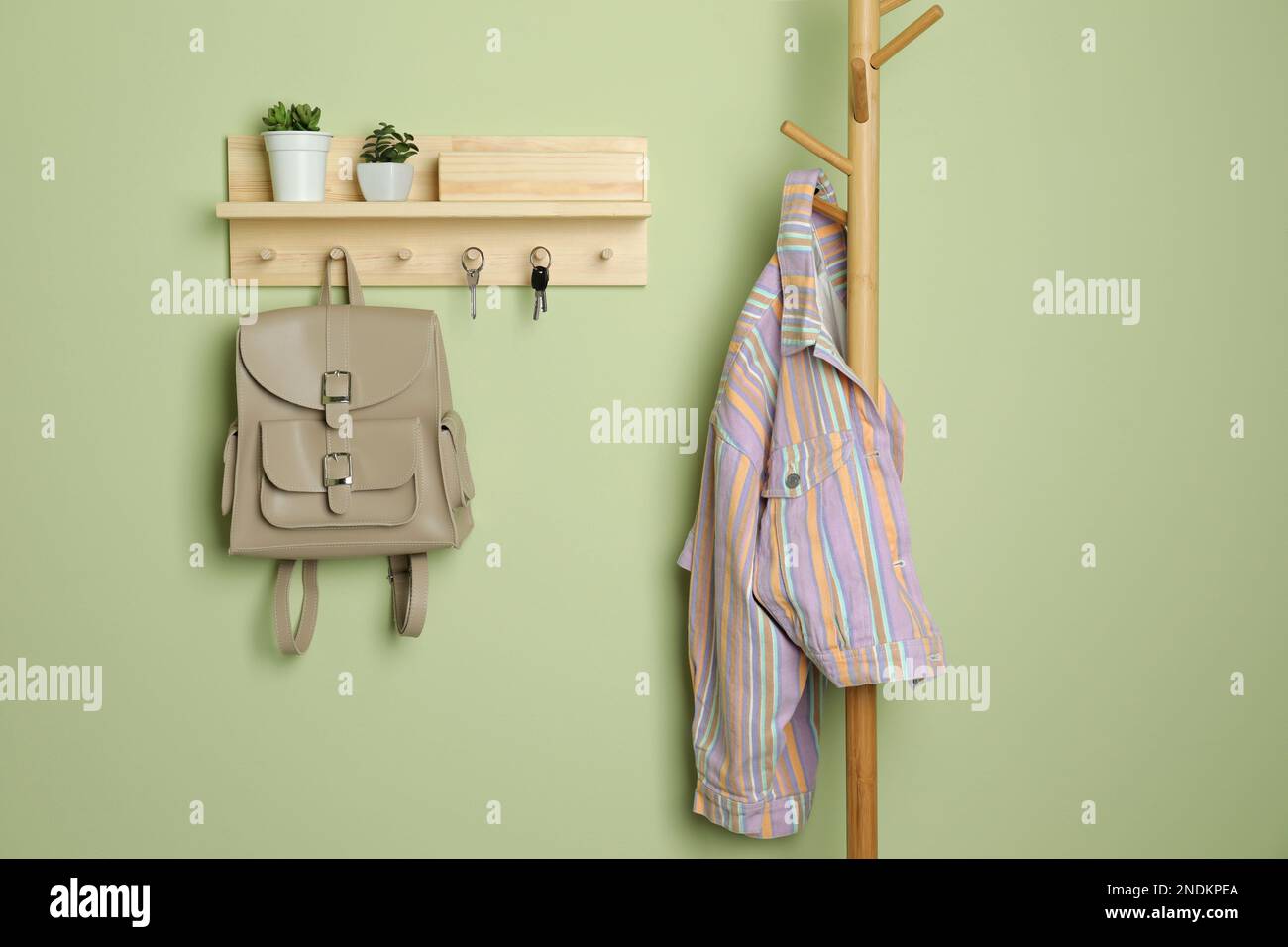 Wooden hanger for keys on light green wall Stock Photo Alamy