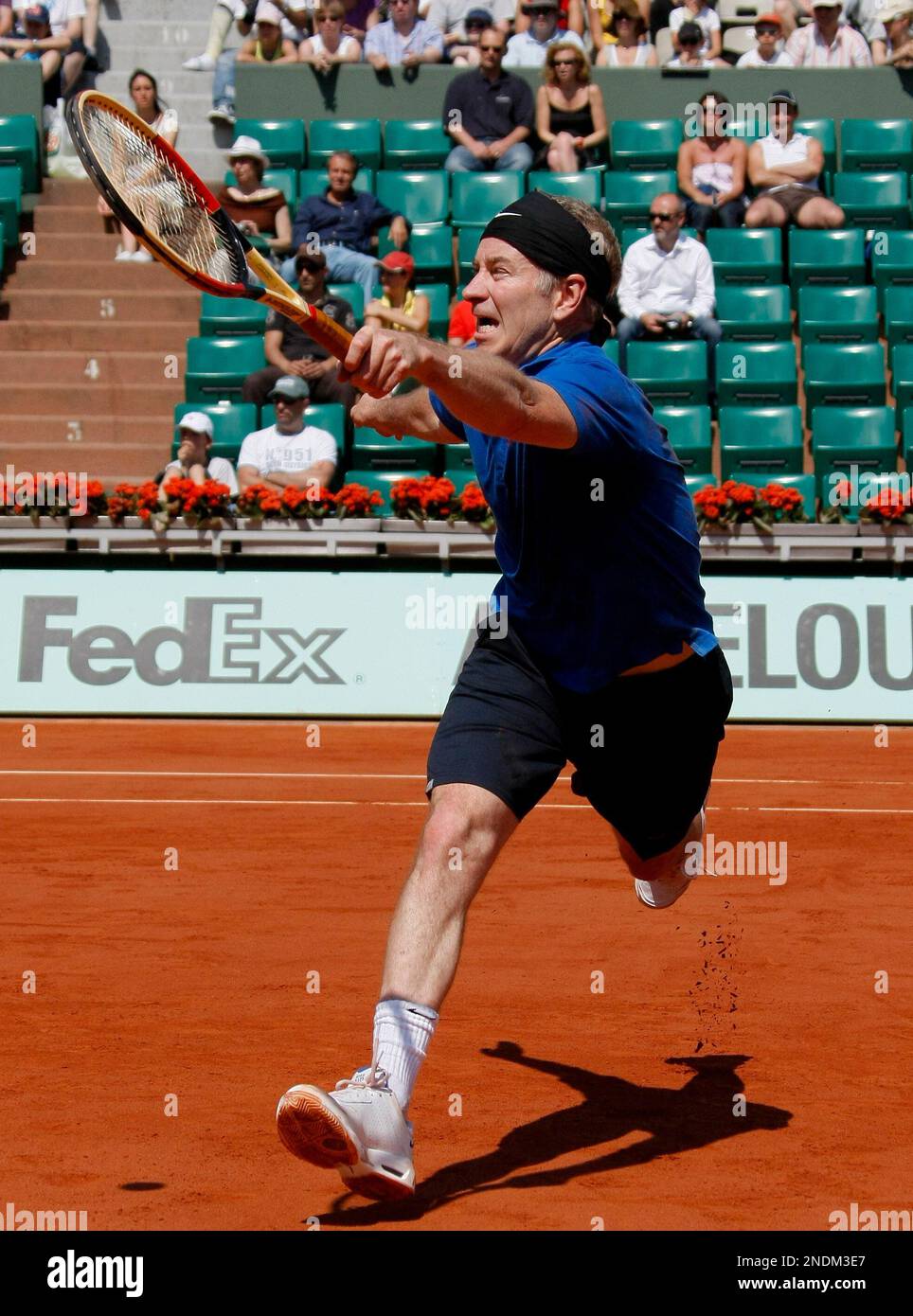 USA's John McEnroe returns the ball to Sweden's Joakim Nystrom and Mats  Wilander during a legends doubles match for the French Open tennis  tournament at the Roland Garros stadium in Paris, Saturday,