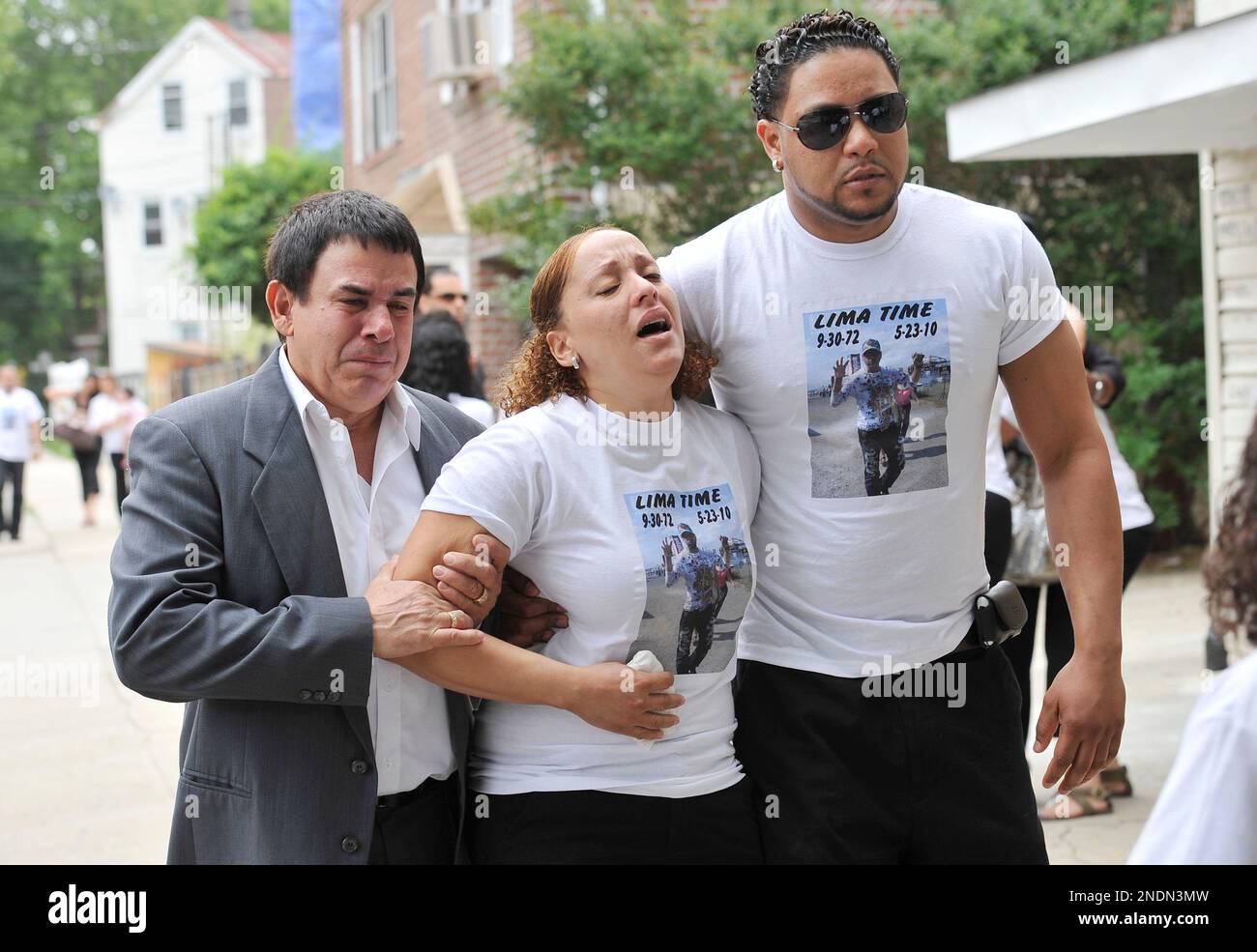 A distraught Belkis Lima Santana is escorted by family friend