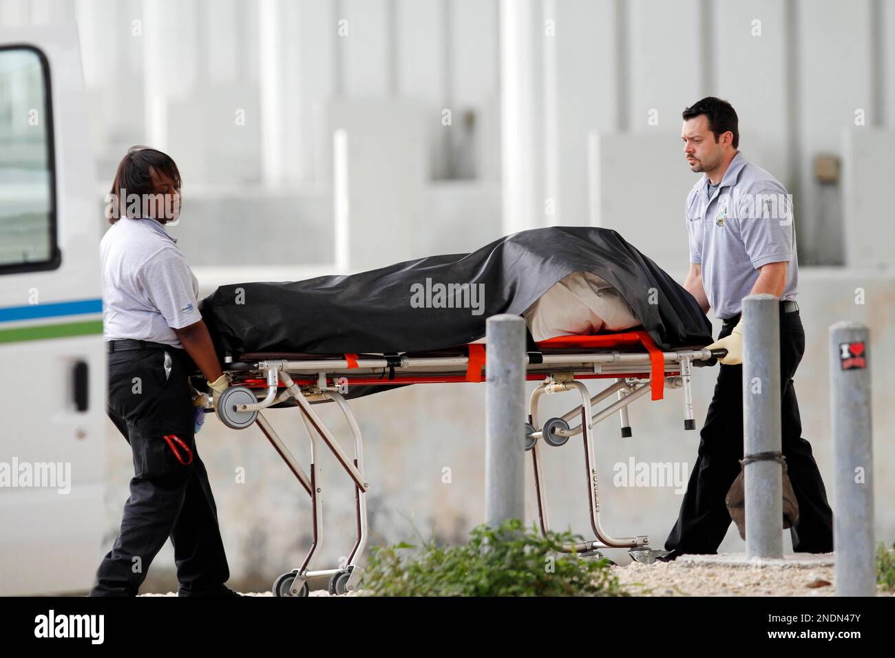 Miami Dade County coroner office workers transport the body of an