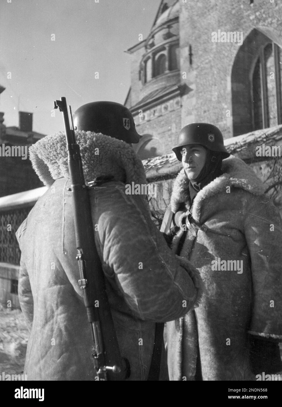Two soldiers from the 10th SS Totenkopf regiment (wearing sheepskins) during the changing of the guard at the Royal Castle in Krakow. Stock Photo