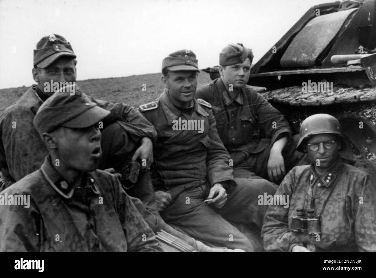 Soldiers of the 3rd SS Panzer division 'Totenkopf' at rest next to a destroyed Soviet tank T-34 in Romania in 1944. Photo Bundesarchiv Bild 101I-024-3535-30, Ostfront, Waffen-SS-Angehörige bei Rast.jpg Stock Photo