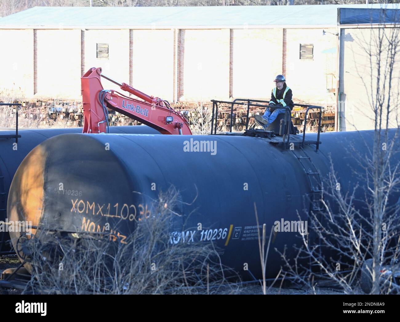 A worker sits on a container at the site where toxic chemicals were