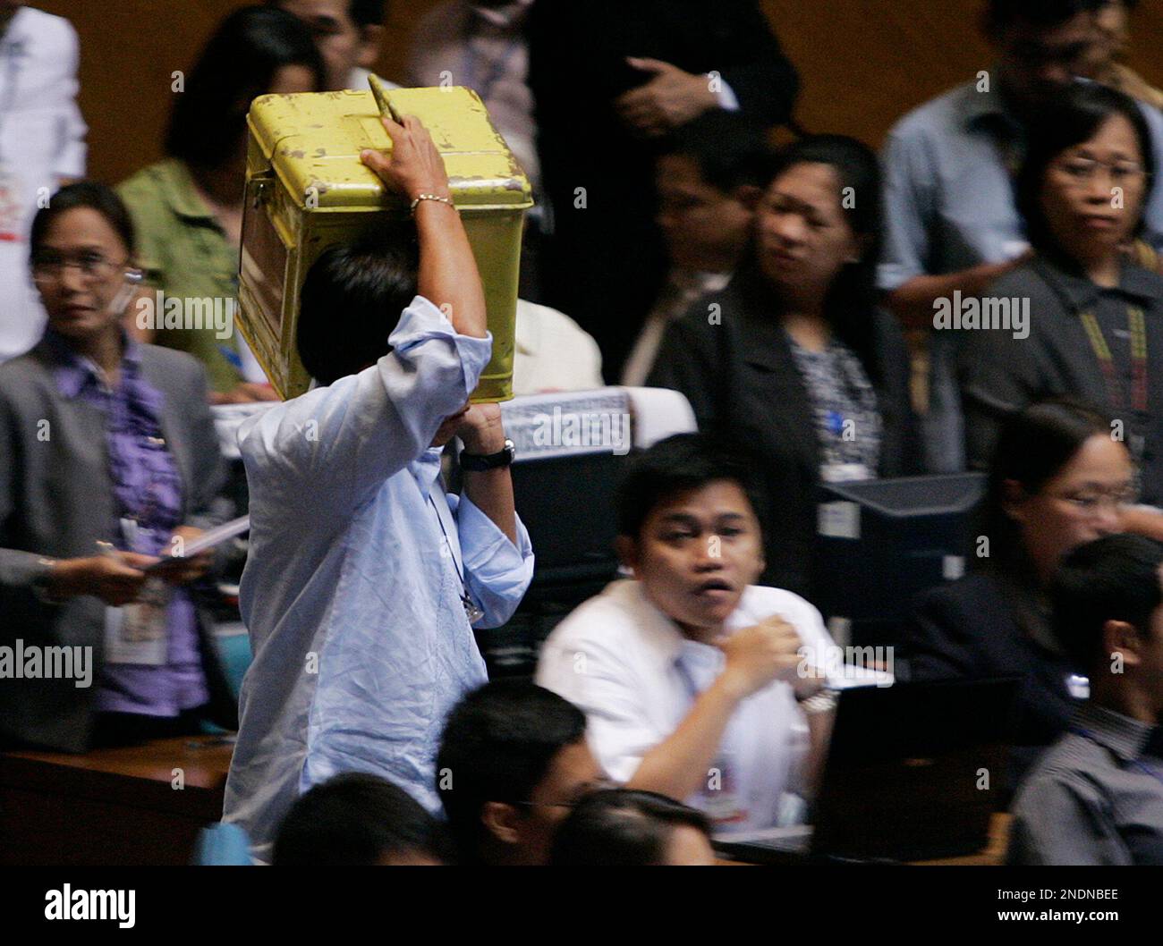 A man carries the first ballot box to be opened by the National Board