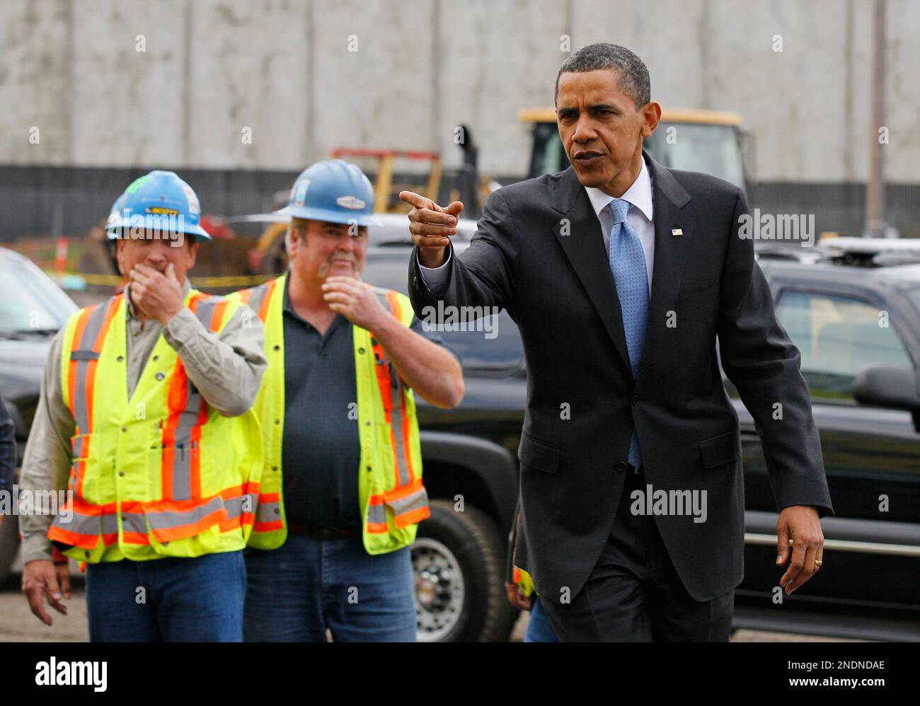President Barack Obama points as he walks into a new Solyndra, Inc., a