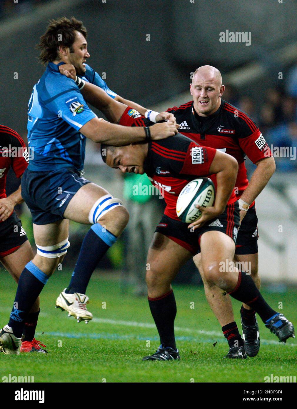 New Zealand Crusaders Ti'i Paulo, right, avoid a tackle from South Africa's  Bulls Pedrie Wannenburg, left, during the semi-finals of the Super 14 rugby  match at the Orlando stadium in Soweto, South