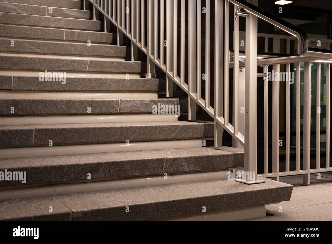 Evening photos of exterior, outdoor building granite steps with hand railing with ambient lighting. Stock Photo