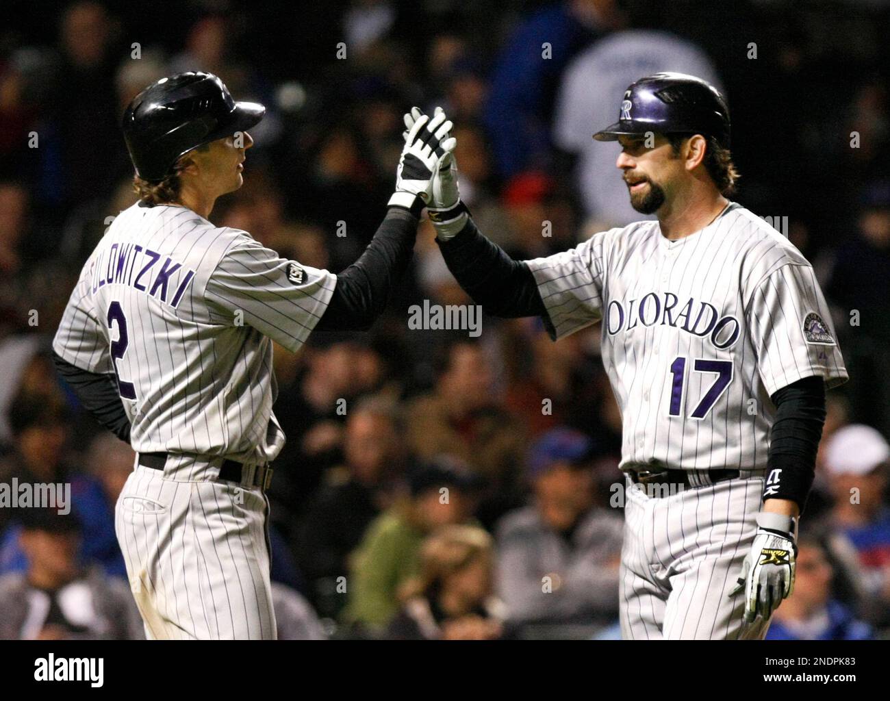Colorado Rockies Troy Tulowitzki left greets Todd Helton at home plate after the pair scored off Helton s two run home run off Chicago Cubs starting pitcher Carlos Silva during the seventh inning of
