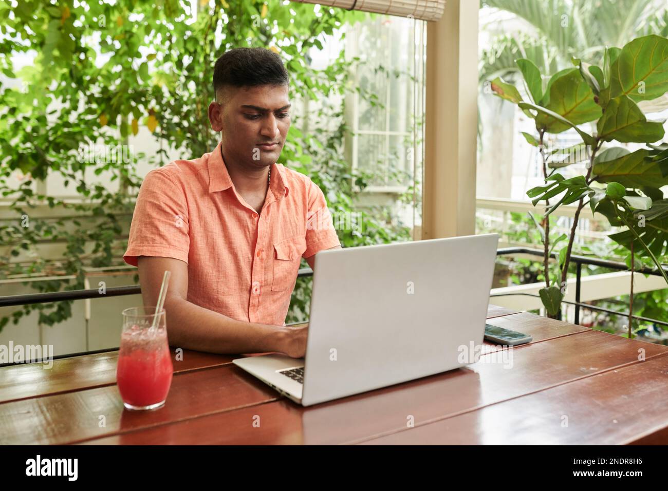 Serious Indian software developer working on laptop in coffeeshop Stock Photo