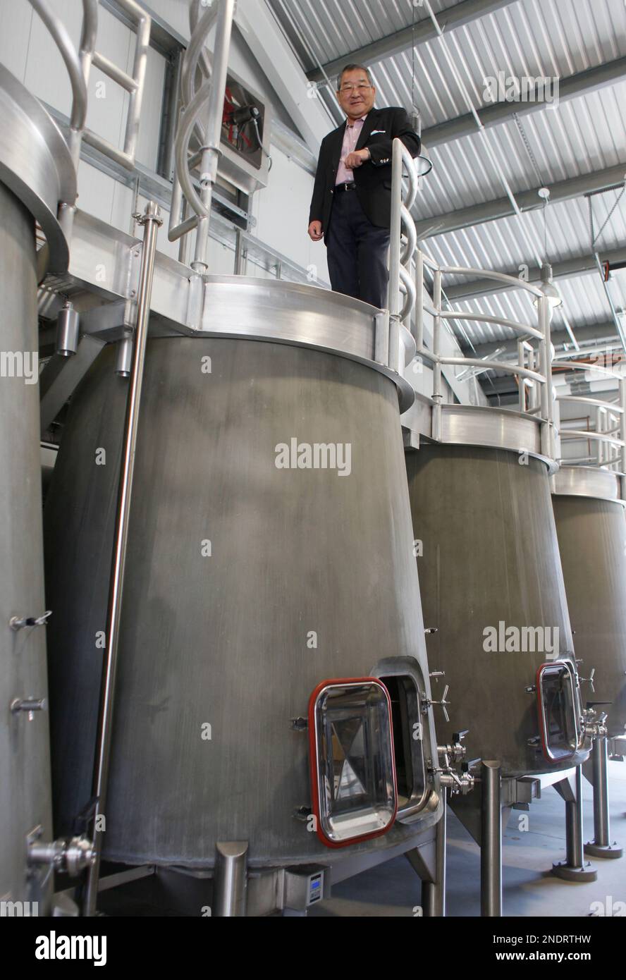 Kenzo Tsujimoto stands atop a concrete fermenter at Kenzo Estate winery ...