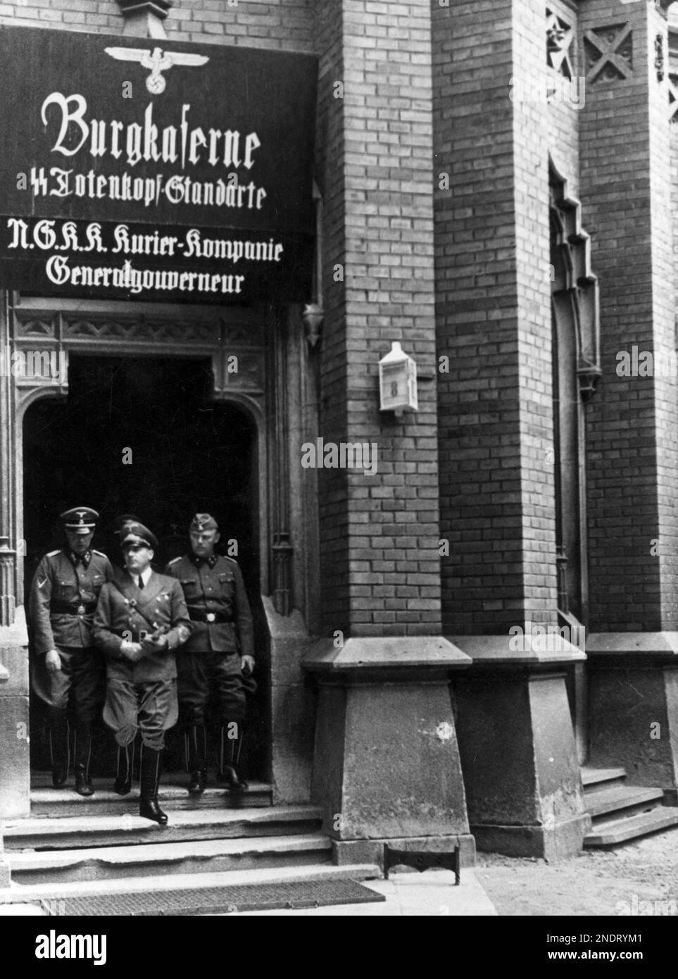 Governor Hans Frank (centre), surrounded by officers, leaves the barracks of the SS Totenkopf regiment and the courier company of the NSKK (National Socialist Car Corps), located at the Royal Castle in Krakow. Stock Photo